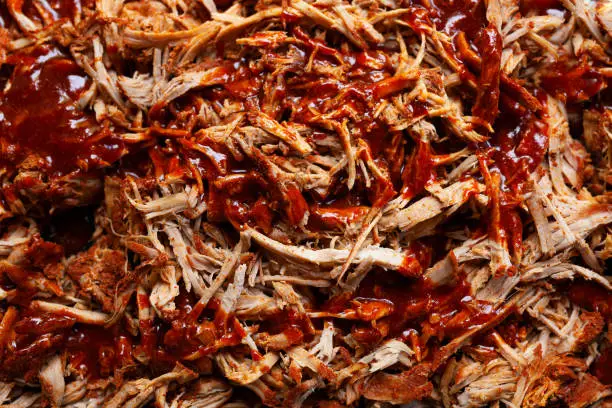 Homemade pulled pork with barbecue sauce on top of it, top view