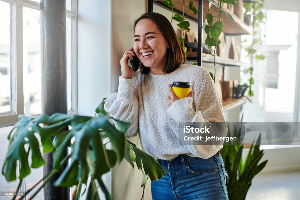 Shot of a young woman talking on the phone at home Here's a dime. Call all your friends Using Phone Stock Photo