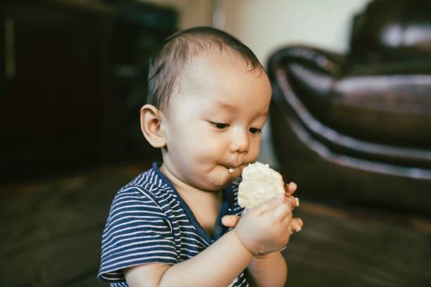 istock Baby boy  sit on floor, face covered with food, smiling 1336115336