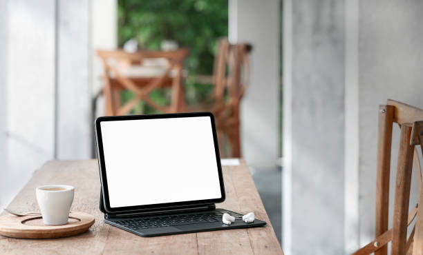 istock Mockup blank screen tablet with magic keyboard on wooden table. 1336115574