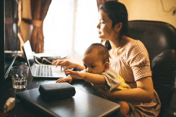 istock mother holding her baby when working from home 1336116606