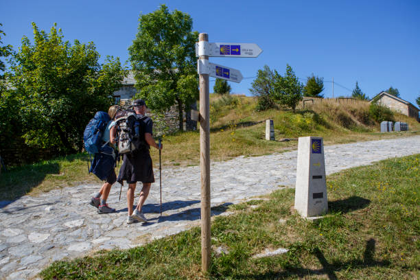 dois peregrinos fazendo o caminho de são tiago enquanto passam por o cebreiro em lugo, espanha - galicia pilgrimage pilgrim religion - fotografias e filmes do acervo