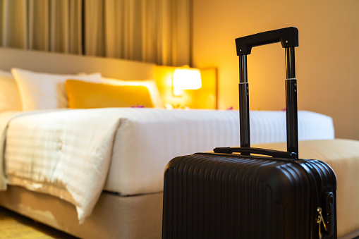 Maleta entregada de pie en habitación de hotel. concepto de servicio hotelero y viajes photo