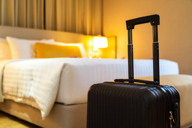 maleta entregada de pie en habitación de hotel. concepto de servicio hotelero y viajes - hotel fotografías e imágenes de stock