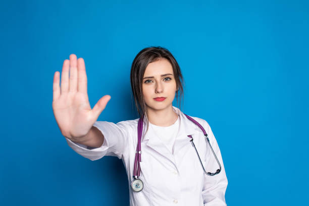 istock attractive woman doctor showing stop gesture refusing standing in blue background 1336116917