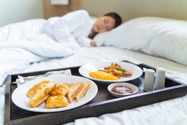 istock Breakfast in bed. Woman sleeping on the bed wake up late 1336117055