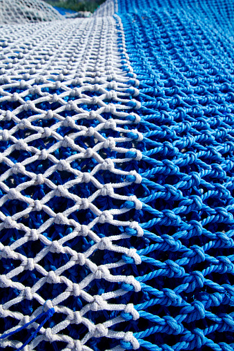 blue and white fishing nets with rope knots for trawling boats
