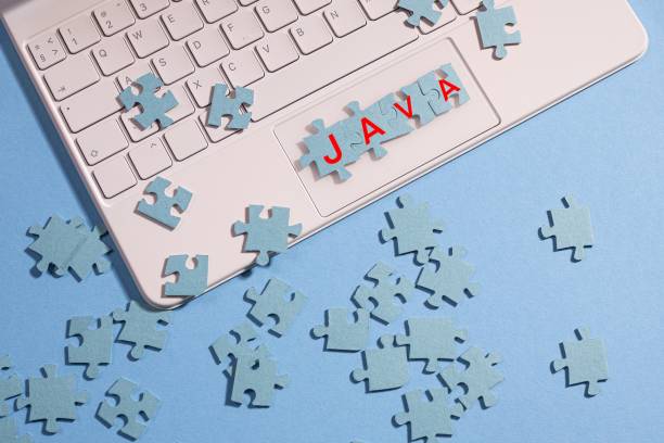 The puzzle pieces are assembled into the word Java, The puzzle pieces are assembled into the word Java, a programming language and application creation, a concept. Mosaic on the computer keyboard, blue background java stock pictures, royalty-free photos & images