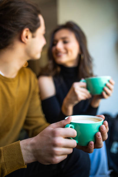 istock Happy young couple is drinking coffee and smiling while sitting at the cafe 1336118153
