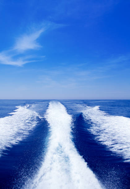 Boat wake prop wash on blue ocean sea in sunny day