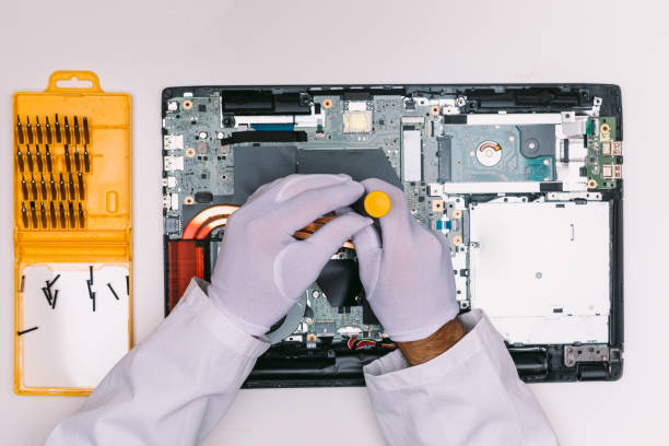 istock View from above of a white gloved hands of an engineer, fixing a laptop on a white table 1336120583