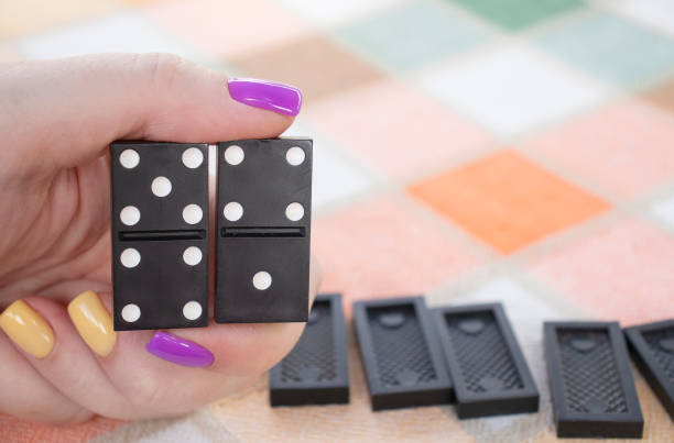 istock People play dominoes. Hand with dominoes close up 1336123785