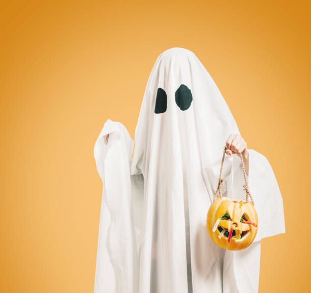 istock Cute ghost holding pumpkin basket with sweet candy. 1336124086