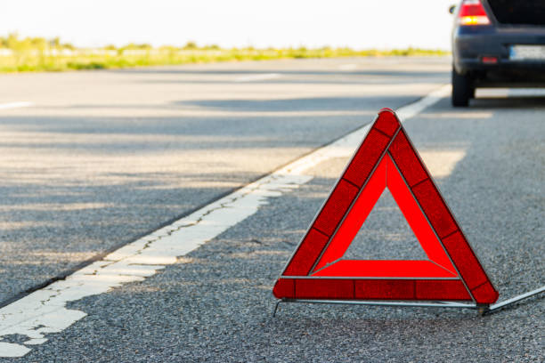 istock Red emergency stop sign (red triangle warning sign) and broken car on road 1336125105