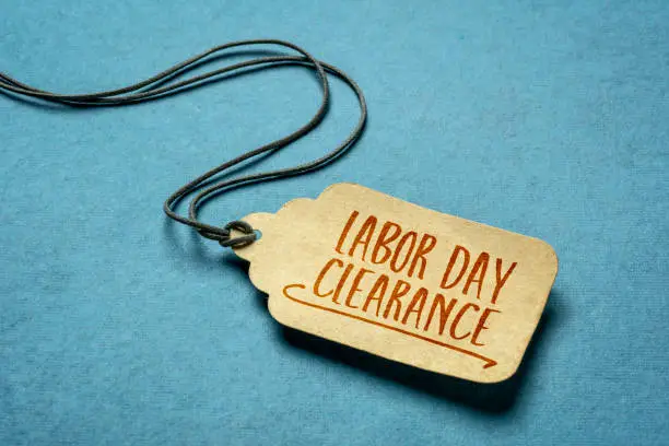 Labor Day clearance sign  - a paper price tag with a twine on blue background, sale and shopping concept