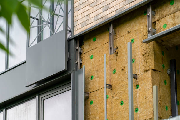 Installation of external wall thermal insulation with rock wool. Exterior passive house wall heat insulation with mineral wool. Insulation facade of multistory residential building. Energy efficiency stock photo