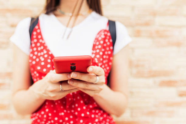 istock Close up woman hands using mobile phone in the street 1336127084