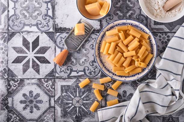 pasta. italian pasta. rigatoni and vegetables cooking ingredients on an old stone background. italian food cooking ingredients. top view with copy space. - cooking oil olive oil nutritional supplement spoon imagens e fotografias de stock