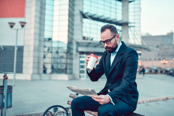 istock Modern Businessman Drinking Takeaway Coffee And Reading Newspaper After Work Outside 1336135812