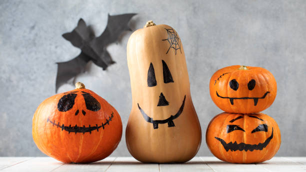 istock Pumpkins with spooky faces on table at Halloween celebration 1336135880