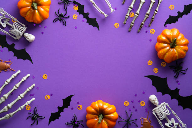 istock Halloween decorations on violet background. Flat lay pumpkins, bats, spiders, skeletons and confetti. Top view with copy space. Halloween concept. 1336140015