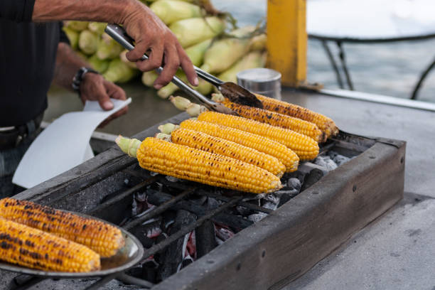 pessoa grelhando milho na espiga - corn corn on the cob grilled roasted - fotografias e filmes do acervo