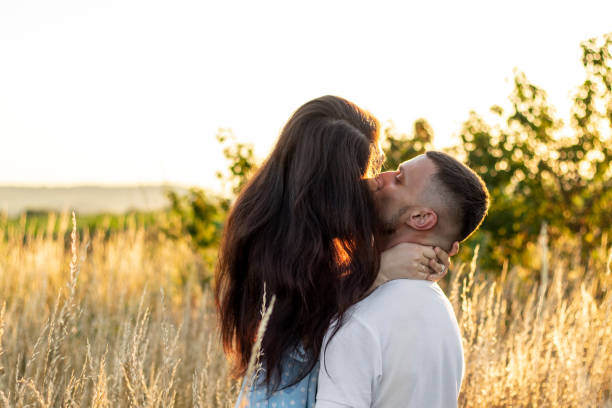 istock Young couple in love in field at sunset. 1336142282