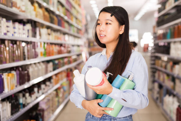 istock Customer holding bottles of shampoo in store 1336143805