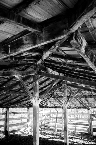 Inside an old farm shed in black and white.