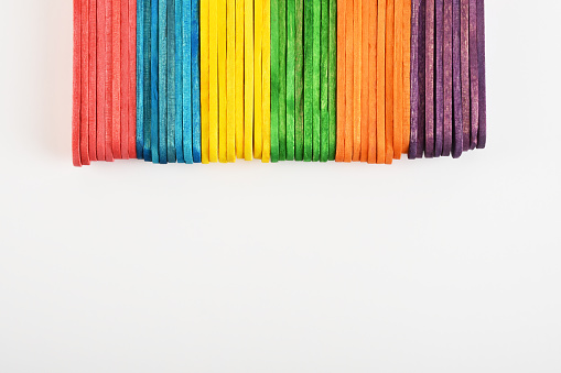 Directly above multi colored ice cream sticks on the white background with copy space