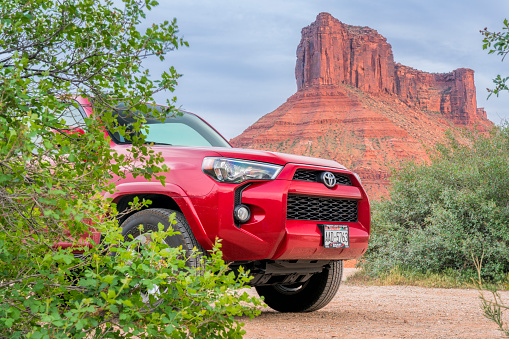 Moab - May 5, 2018: Toyota 4Runner SUV  and a sandstone butte in Utah landscape at Rocky Rapid river access area.