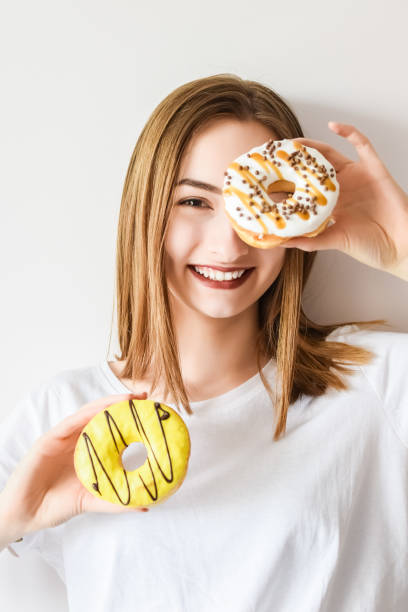 istock Beautiful girl holding donuts and having fun 1336148395