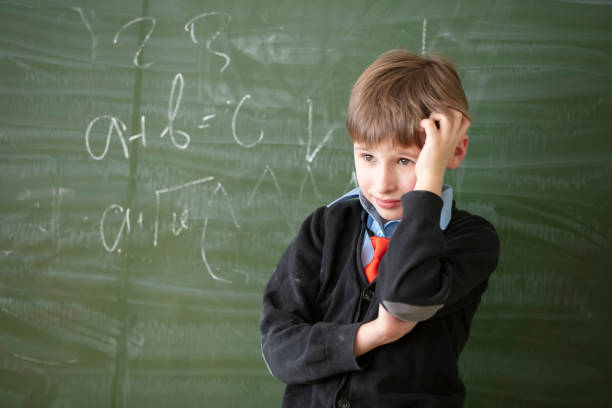 istock Child student in the classroom. The student at the green board is solving a difficult problem. Primary school education. 1336151058