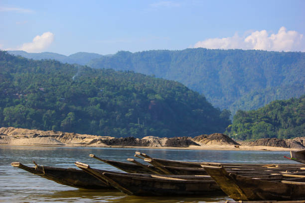 Lots of Wooden Row boats anchored at mountainous river shore in Sylhet, Bangladesh. This picture was taken while traveling sylhet which is most famous place of Bangladesh during winter vacation. sylhet stock pictures, royalty-free photos & images