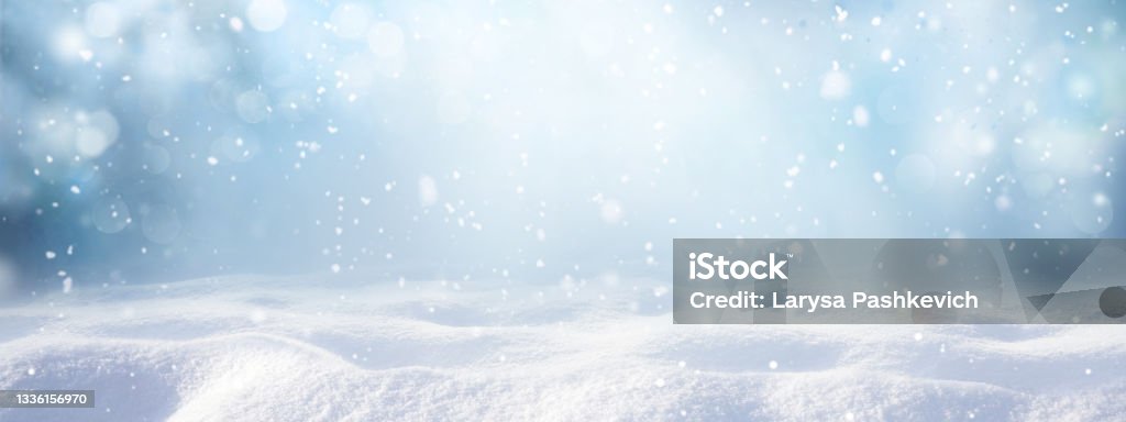 Winter snow background with snowdrifts, with beautiful light and snow flakes on the blue sky. Winter snow background with snowdrifts, with beautiful light and snow flakes on the blue sky, beautiful bokeh circles, banner format, copy space. Snow Stock Photo