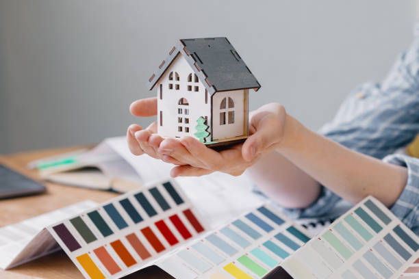 istock a beautiful small model of a house in women's hands 1336159608