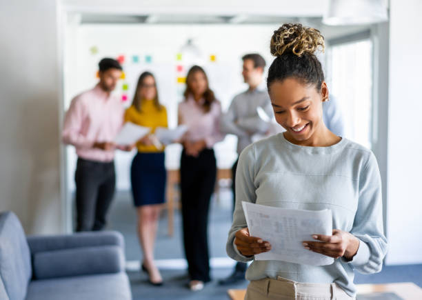 istock Happy business woman working at the office and holding documents 1336160920
