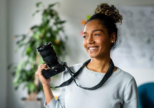 Fotógrafa independiente sosteniendo una cámara photo