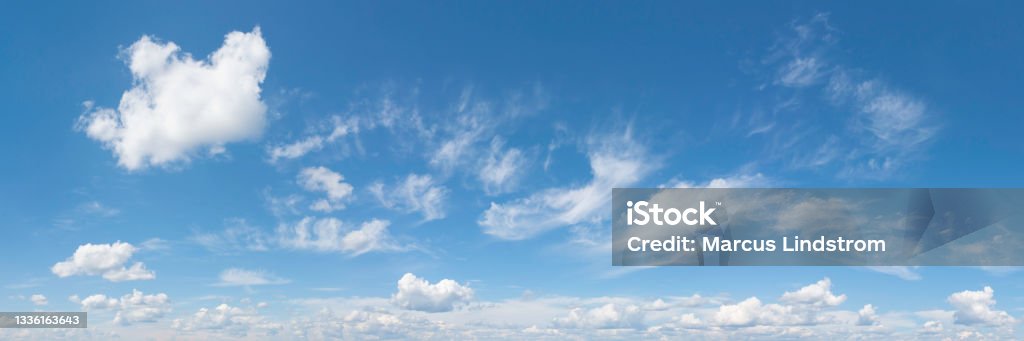 Bright summer sky on a beautiful day White clouds in a blue sky in summer. Panoramic skyscape in 1:3 format. Sky Stock Photo