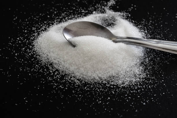 istock heap of sugar with a teaspoon on black background 1336165713