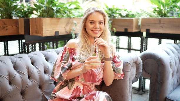 istock Woman drinking fresh beverage on sofa 1336172413