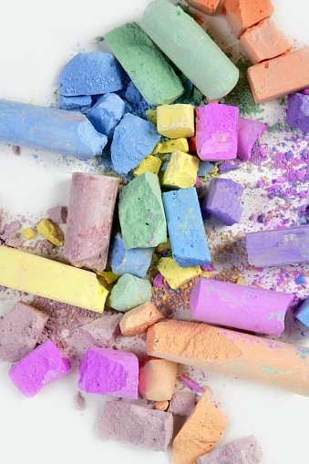 Colorful chalk broken colors mess over white background