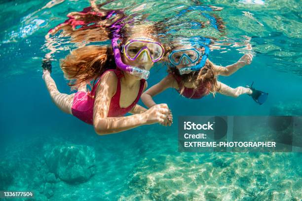 Sisters Snorkeling And Playing Underwater Stock Photo - Download Image Now - Snorkeling, Snorkel, Beach