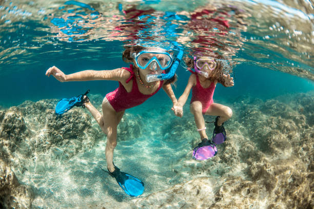 istock Sisters snorkeling and playing underwater 1336178326