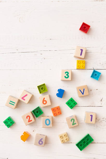 istock Developing multi-colored cubes on a white wooden table. Wooden cubes with numbers 2021 and others. Top view of the numbers of the year and other educational toys. 1336180063