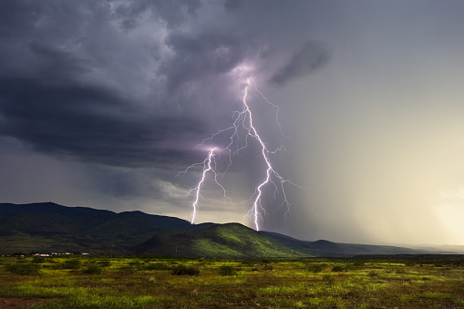 Twin lightning bolts strike the Peloncillo Mountains during a monsoon storm near Clifton, Arizona.