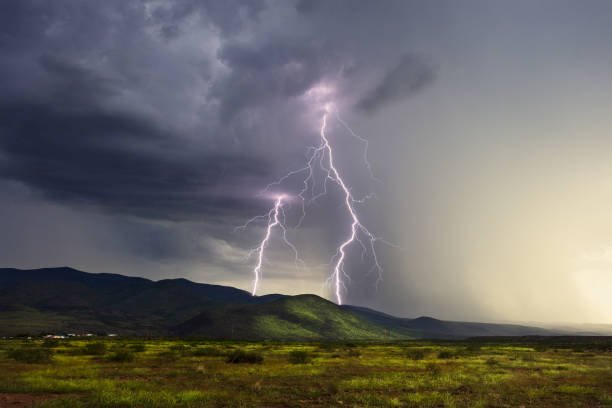 Lightning bolts strike a mountain in a storm stock photo