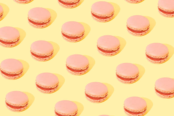 istock Pink Macarons arranged in a pattern on a yellow background. Sweet food cake concept 1336186102