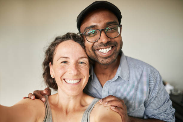 istock Smiling young couple talking a selfie together at home 1336192067