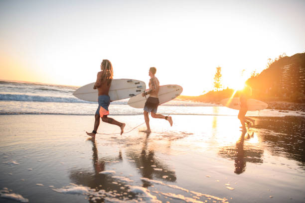 istock Gold Coast Surfers Running with Boards at Water’s Edge 1336192739